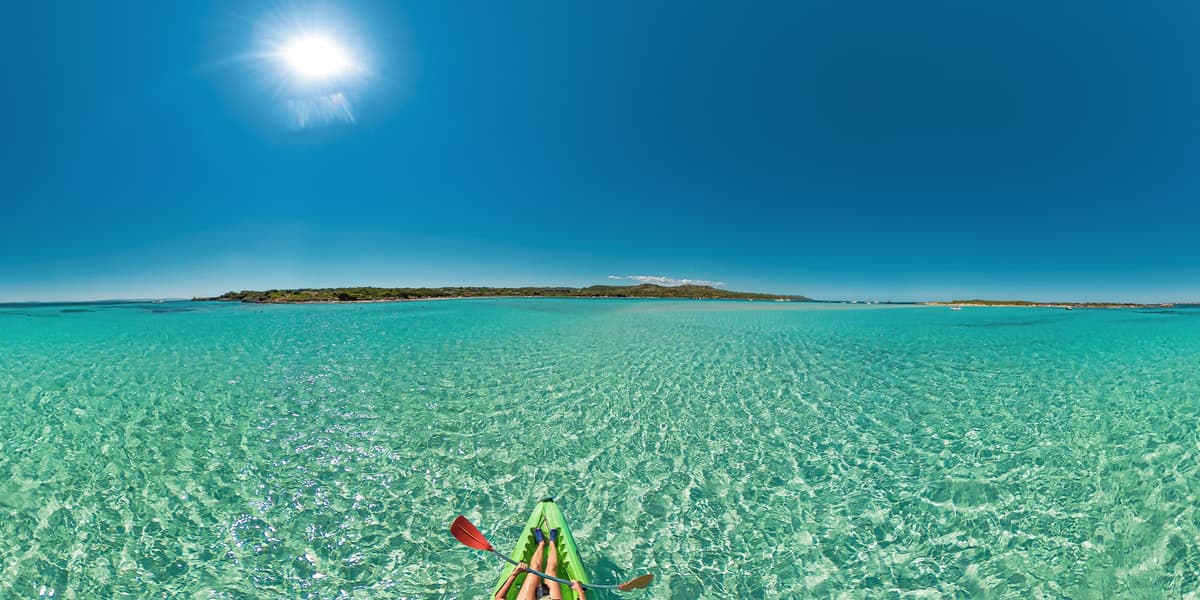 Kayaking across bright turquoise Algarve waters on a sunny day