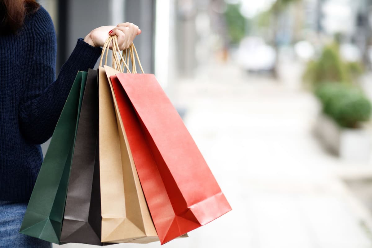 Colourful shopping bags held on a sunny high street