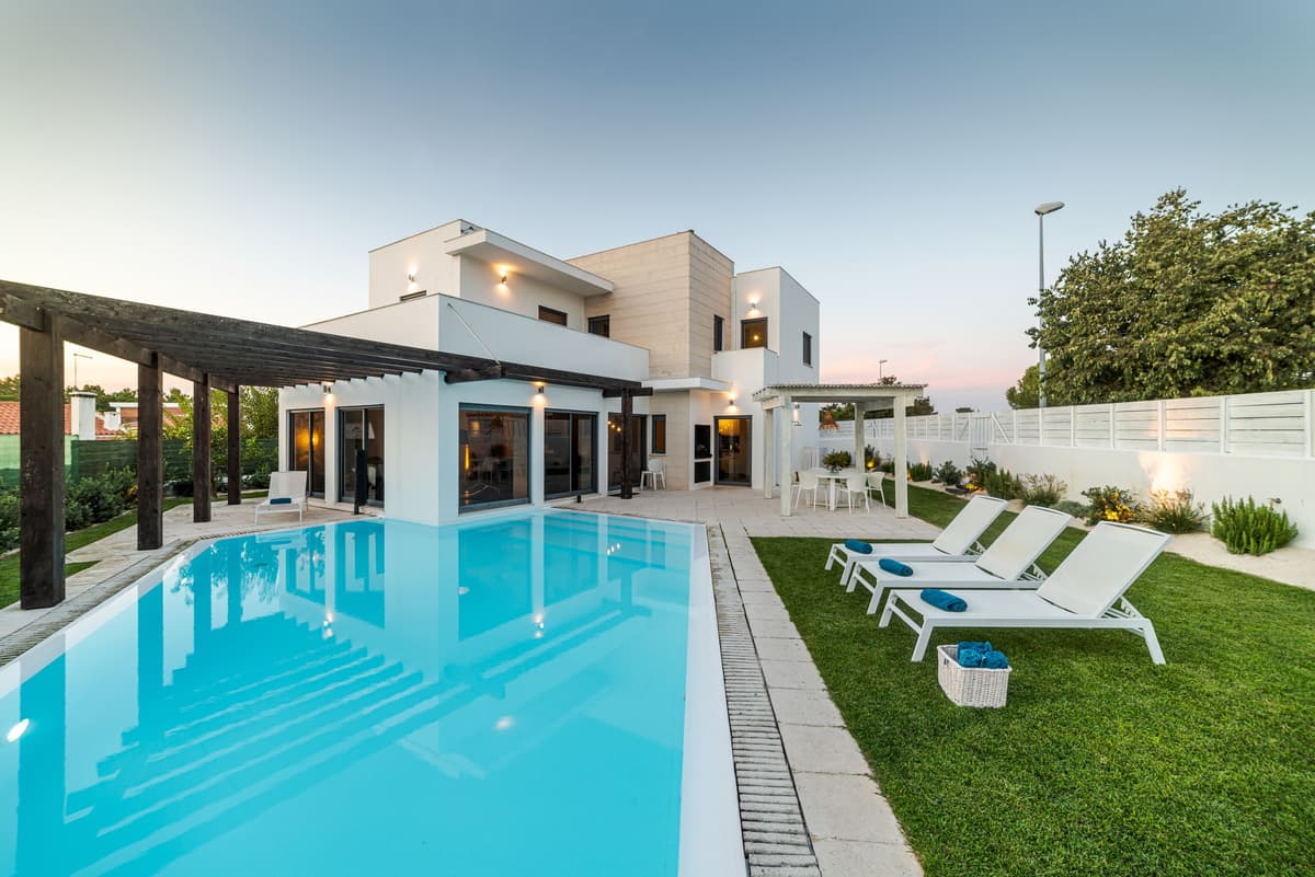 A modern Algarve villa with a swimming pool at dusk